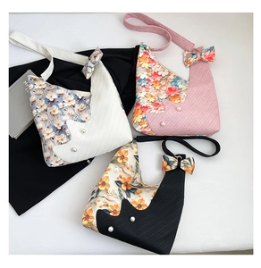 Detailed flat lay of tulip pattern tote bags with pearl accents in white, pink and black