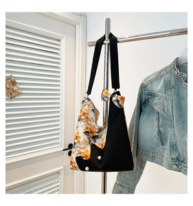 Detail of yellow floral tote bag with white pearl accents and a decorative bow tie