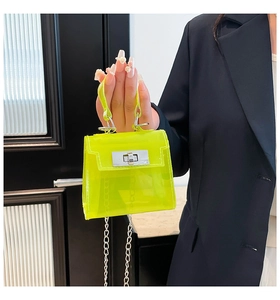 Detalle del mini bolso de PVC traslúcido amarillo neón con hebilla plateada y correa cadena