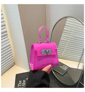 Detalle de mini bolso de charol rosa con cierre giratorio de plata y cadena