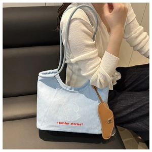 Light blue denim tote bag detail featuring cute puppy embroidery and brown pendant decoration