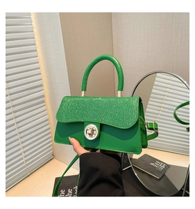 Detail of emerald green leather handbag with glittery sequin flap and silver clasp