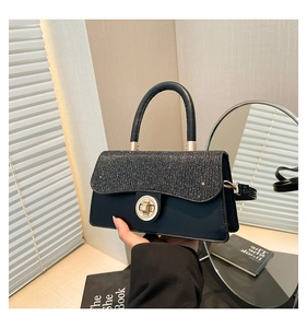 Detailed macro view of the sparkling sequined flap and golden twist lock on this chic black bag