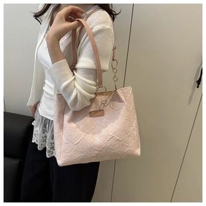 Detail of pink embroidered tote bag with daisy patterns and metallic chain strap