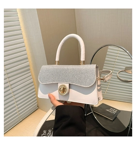 Detailed view of the sparkling silver rhinestone flap and golden ring twist lock closure