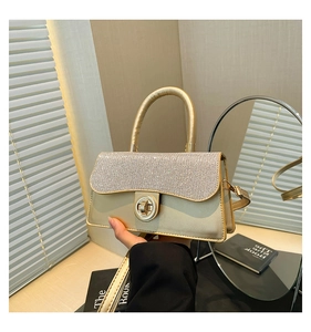 Detail of evening bag with silver rhinestones and gold satin finish on metal clasp