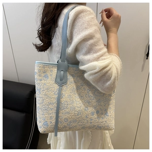 Detail of woven tote bag with light blue leather trim and delicate wave texture