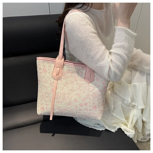 Close-up of pink and beige woven texture with leather trim on a fashion tote bag