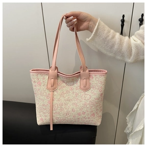 Close-up of pink and beige woven straw texture with premium leather strap detail