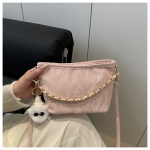 Detailed view of pink marble tote with gold chain strap and cute white plush charm