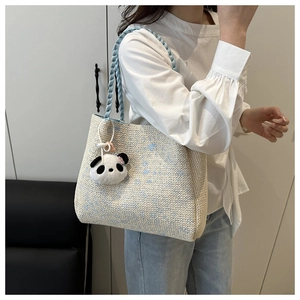 Détail du sac cabas en paille avec anses en corde bleu clair et pendentif panda