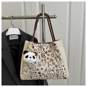 Détail d'un sac cabas en tricot avec imprimés graffiti et joli pendentif panda en peluche