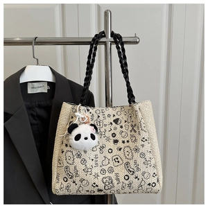 Détail d'un pendentif panda en peluche et motifs de dessins animés sur un sac tissé