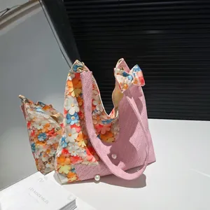 Pink tweed tulip tote bag with 3D floral accents and pearl details on a mirrored surface