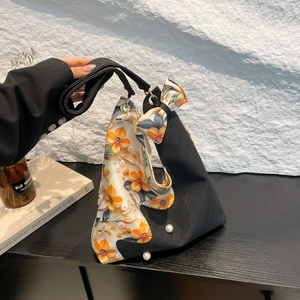 Unique tulip-shaped shoulder bag in black weave and orange satin with pearl accents