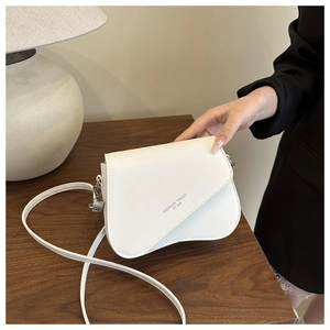 Close-up of white PU leather crossbody bag with irregular flap and 1996 fashion text