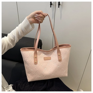 Detail of light pink tote bag featuring intricate jacquard texture and metal logo