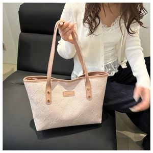 Detailed embroidery of white bows on the pink quilted leather tote bag with logo