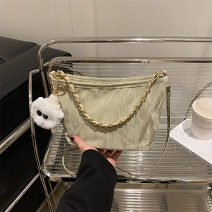 Sage green pleated shoulder bag with gold chain and plush monster charm for women