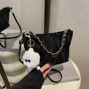 Fashionable black pleated tote bag with gold chain, long strap and plush doll charm