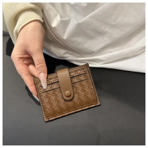 Detailed view of brown woven leather card holder with secure button strap and multi-slots