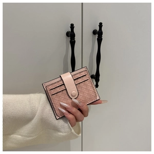 Close-up of a pink woven leather card holder with multiple card slots and snap closure