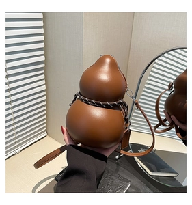 Detail of brown gourd-shaped crossbody bag with decorative rope and smooth leather texture