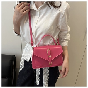 Détail du sac bandoulière fuchsia avec boucle en métal doré et bandoulière fine