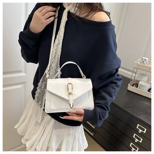Détail du sac à main blanc avec fermoir doré et bandoulière ornée de dentelle fine