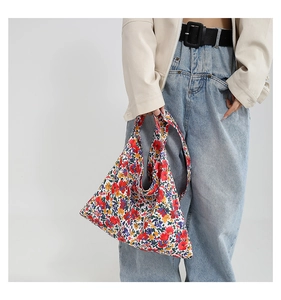Detail view of large capacity floral tote bag showing colorful patterns and shoulder strap