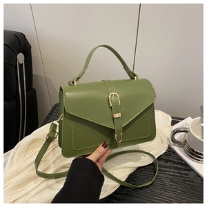 Détail du sac enveloppe vert sauge avec boucle dorée et finition en cuir mat lisse