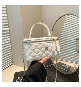 Detailed view of white quilted vanity bag featuring a gold rose metal fastener and chain