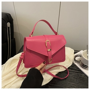 Détail du sac bandoulière rose fuchsia avec boucle dorée et poignée supérieure chic