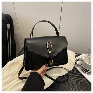 Détail du sac bandoulière noir avec boucle dorée en U et texture en cuir synthétique fin