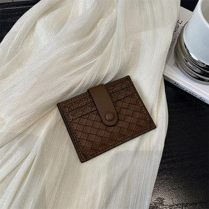 Brown woven leather driver license holder with snap button closure on white fabric