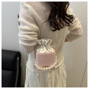 Close-up of pink snakeskin pattern bucket bag with pearl handle and golden chain
