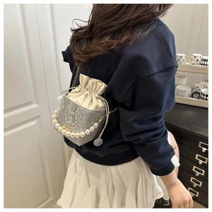 Detail of grey snakeskin bucket bag featuring pearl handle and drawstring interior