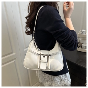 Detailed side view of white faux leather crescent bag with metallic buckle and zippers