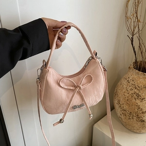Chic pink crescent leather handbag with bow detail and silver logo for women