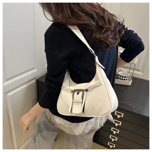 Detail of white hobo bag with decorative buckles and dual zippers on faux leather
