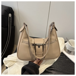 Detail of beige faux leather shoulder bag with large metal buckle and zip pocket features