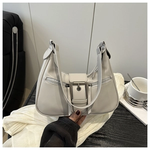Detail der hellgrauen Hobo-Tasche mit Metallschnalle und dekorativen Reißverschlüssen