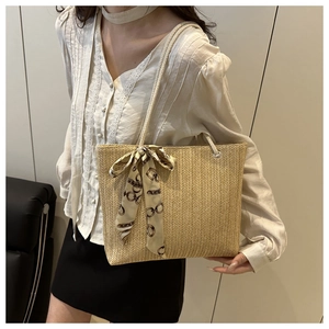 Close-up of beige woven tote bag with V-shaped texture and decorative chain silk scarf