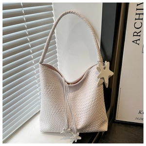 Détail de la texture tissée du sac fourre-tout blanc avec des pendentifs en étoile