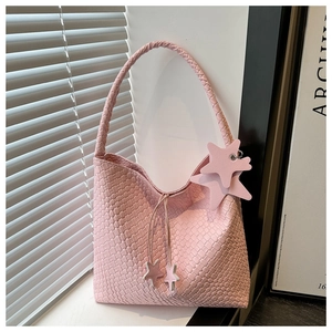 Détails de la texture du sac à bandoulière tressé rose avec pendentif étoile et cordon