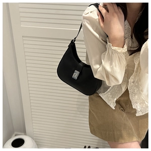Close-up of black leather hobo bag with minimalist silver metal buckle for women
