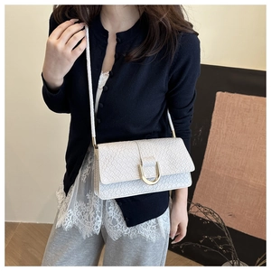 Detail of white woven flap bag featuring a luxury gold U-shaped metal buckle and strap