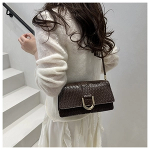 Detailed view of dark brown faux leather shoulder bag with crocodile texture and golden buckle