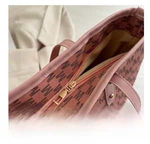 Close-up of pink monogram tote bag with smooth light gold zipper and pebbled texture