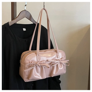 Detailed view of pink glossy faux leather shoulder bag with decorative bow pleated pockets